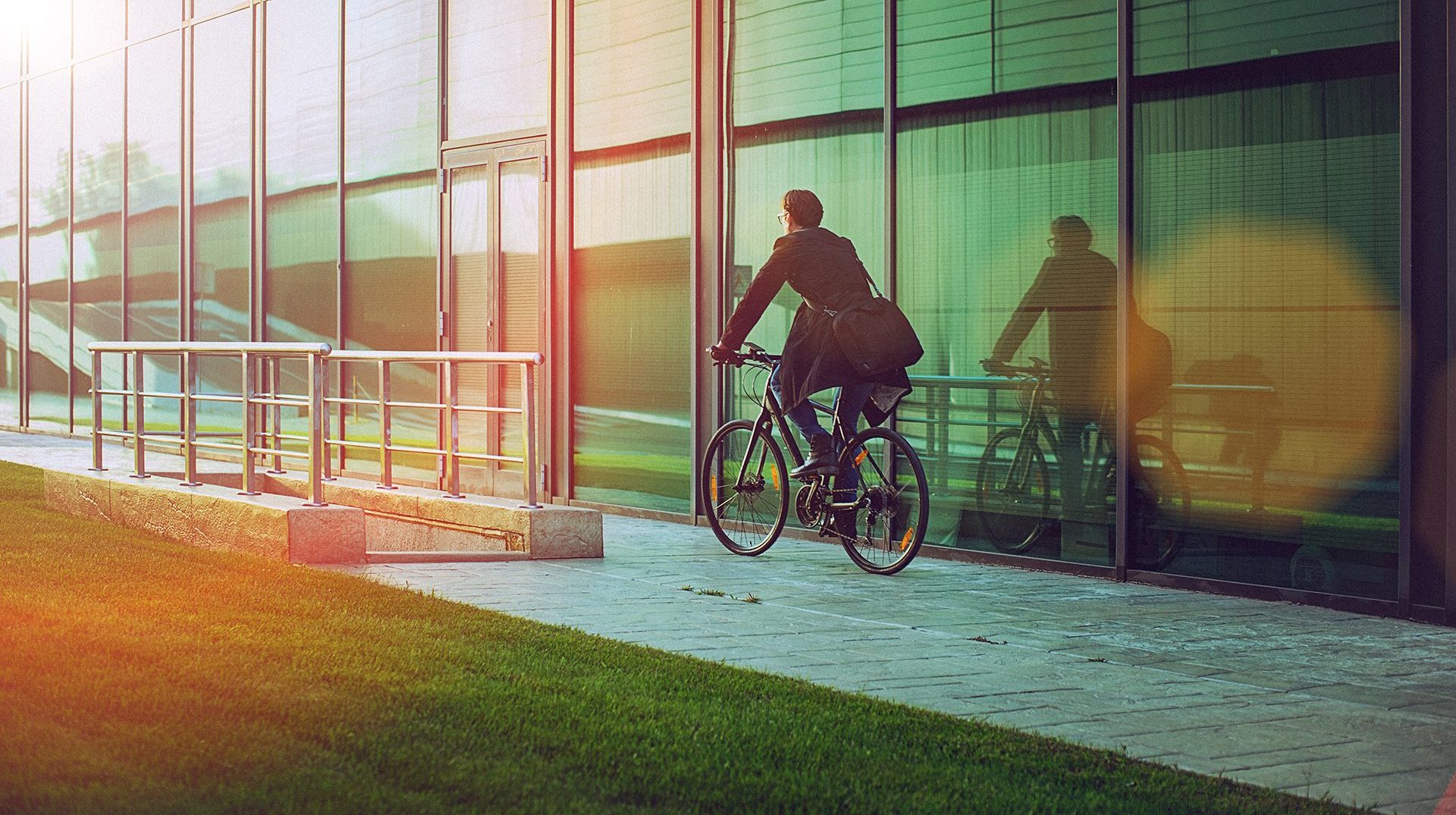 man riding bicycle beside the modern office building