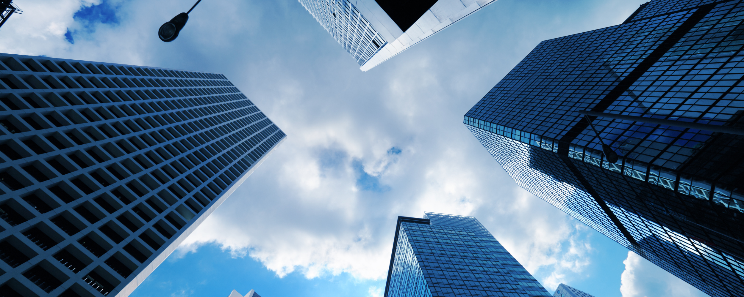 A picture of large commercial buildings and a blue sky with cloud