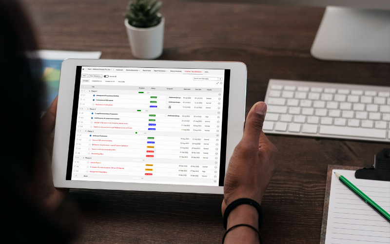 A person holding a tablet computer with a software application running